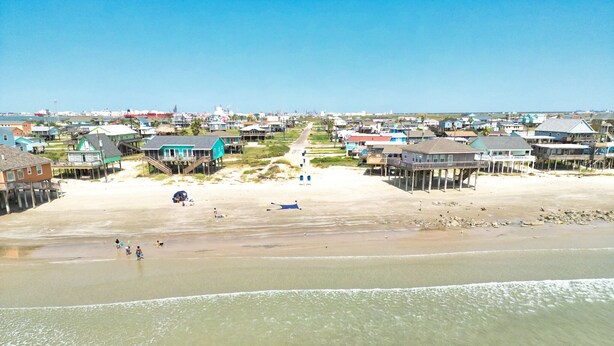 A coastal town with beachfront properties, including houses and buildings with waterfront views. - NEW: Beach House 3-Bed/2-Bath with Ocean View & Golf Cart -- Great Beach (Surfside Beach)