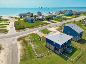 An aerial view of a coastal residential area with houses, a road, and a beach. - NEW: Beach House 3-Bed/2-Bath with Ocean View & Golf Cart -- Great Beach (Surfside Beach)