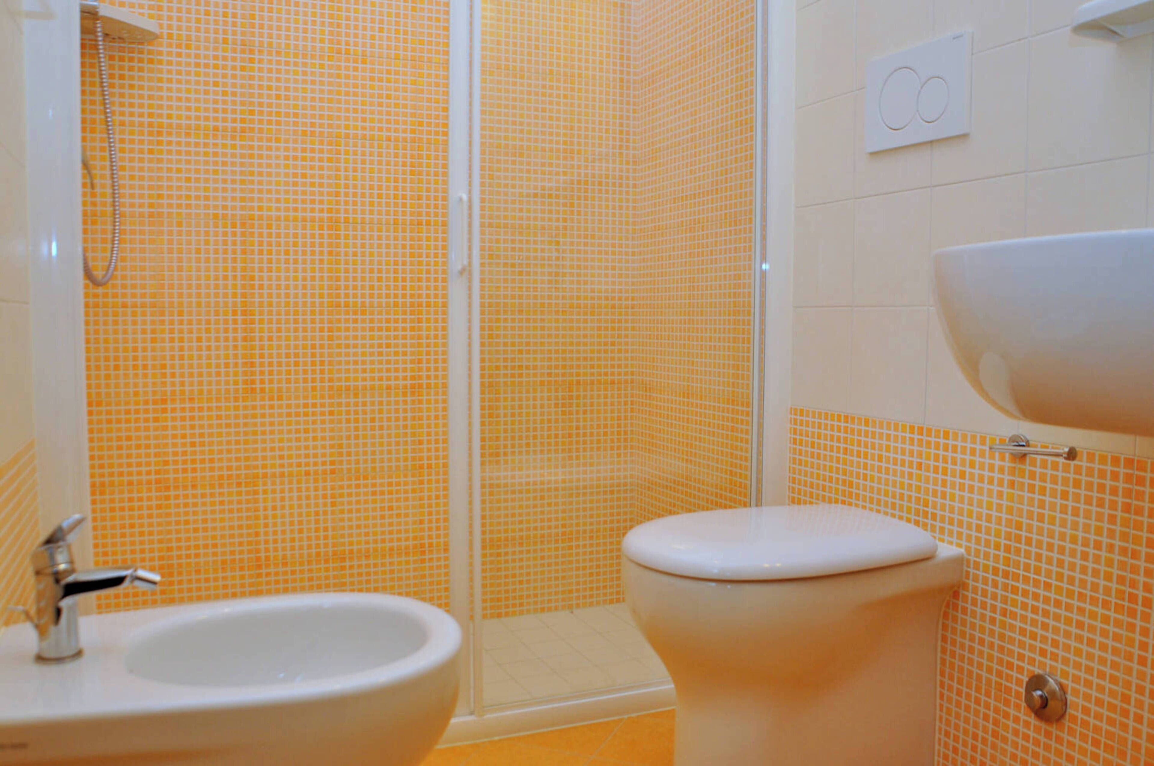 Ein Badezimmer mit Dusche, Toilette und Waschbecken.