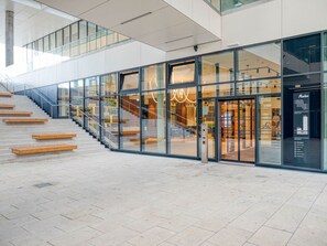 Experience the inviting entryway and modern design of this contemporary building, featuring a mezzanine level and glass facade.