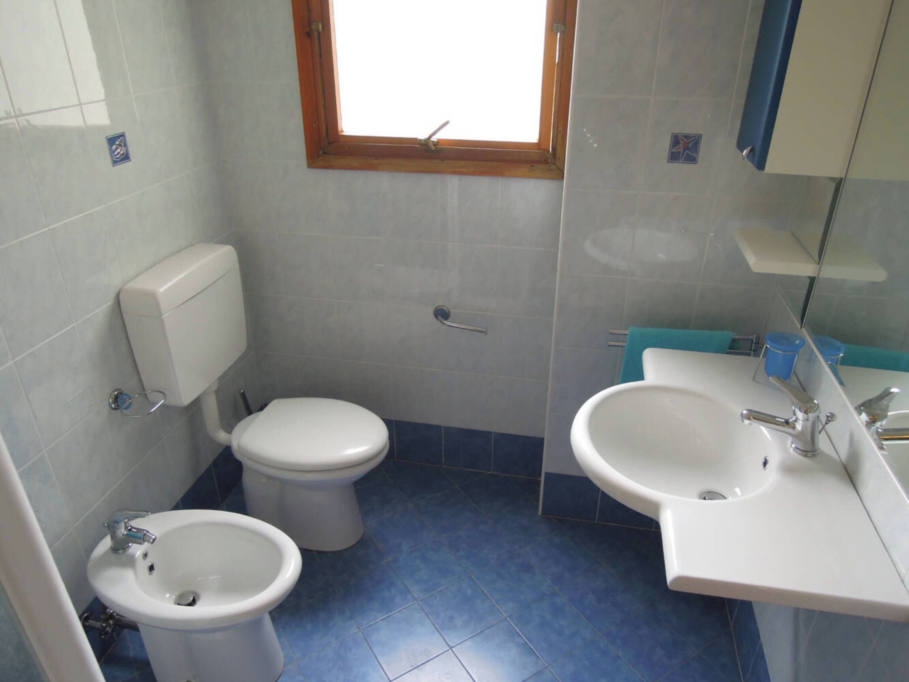 Ein kleines Badezimmer mit Toilette, Bidet und Waschbecken.