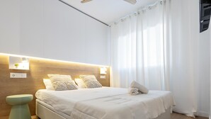 Ein modernes Schlafzimmer mit einem großen Bett, Nachttischlampen und einem Holzkopfteil.
