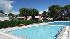 Una piscina con bordes de azulejos y una escalera metálica.