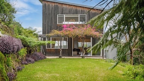 Een modern huis met een groot raam en een overdekte veranda.