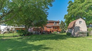 Un quartier résidentiel comprenant une maison à deux étages, une dépendance plus petite attenante et une pelouse bien entretenue.