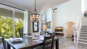 A dining area with a table set for four, a ceiling fan, and a view of the outdoors. - 2 - bedroom Waikoloa Townhouse 106, close to beaches and restaurants (Waikoloa Village)