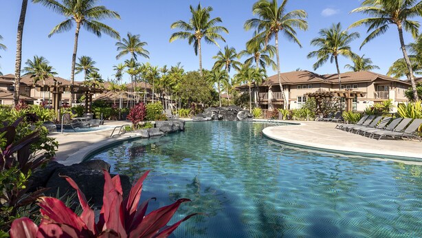 A resort pool with palm trees, lounge chairs, and a waterfall feature. - 2 - bedroom Waikoloa Townhouse 106, close to beaches and restaurants (Waikoloa Village)