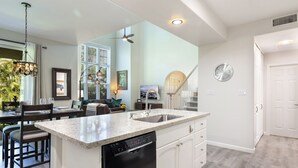 A modern kitchen with a central island, dishwasher, and white cabinetry. - 2 - bedroom Waikoloa Townhouse 106, close to beaches and restaurants (Waikoloa Village)