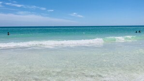 Una spiaggia con acqua turchese cristallina e onde calme.