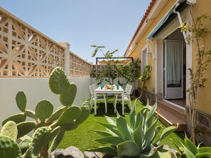 A patio with a table and chairs, surrounded by cacti and a small garden. - Casa Marcelo, charming and renovated house (Antigua)