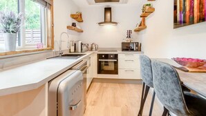 Eine moderne Küche mit Backofen, Mikrowelle und einer Essecke mit Tisch und Stühlen.
