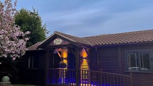 Ein Holzhaus mit Veranda, einem Schild über dem Eingang und einem Geländer.