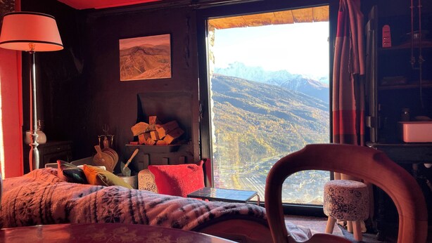 A cozy room with a large window offering a mountain view, a fireplace with logs, and a comfortable seating area. - Chalet mountain and dog friendly, hot tub (Bourg-Saint-Maurice)