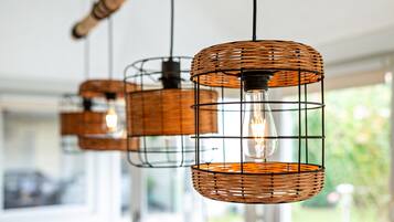Een reeks rieten hanglampen met zichtbare gloeilampen, bevestigd aan een plafond.