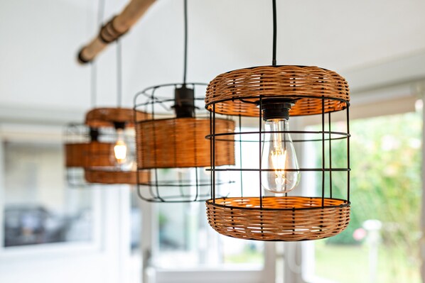 A series of wicker pendant lights with exposed bulbs, hanging from a ceiling.