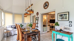 Un comedor con una mesa de madera, sillas y lámparas colgantes.