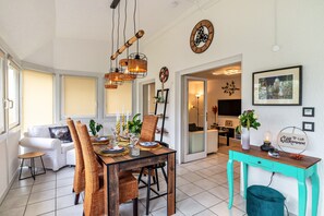 A dining area with a wooden table, chairs, and hanging light fixtures.