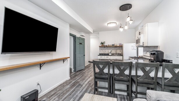 A modern kitchen with white cabinets, a built-in oven, and a coffee machine. - 1103#203 / Downtown Oasis: En-Suite Master (Dubuque)