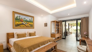 Quarto com uma cama grande, cabeceira de madeira, um banco, uma estante e um quadro na parede.