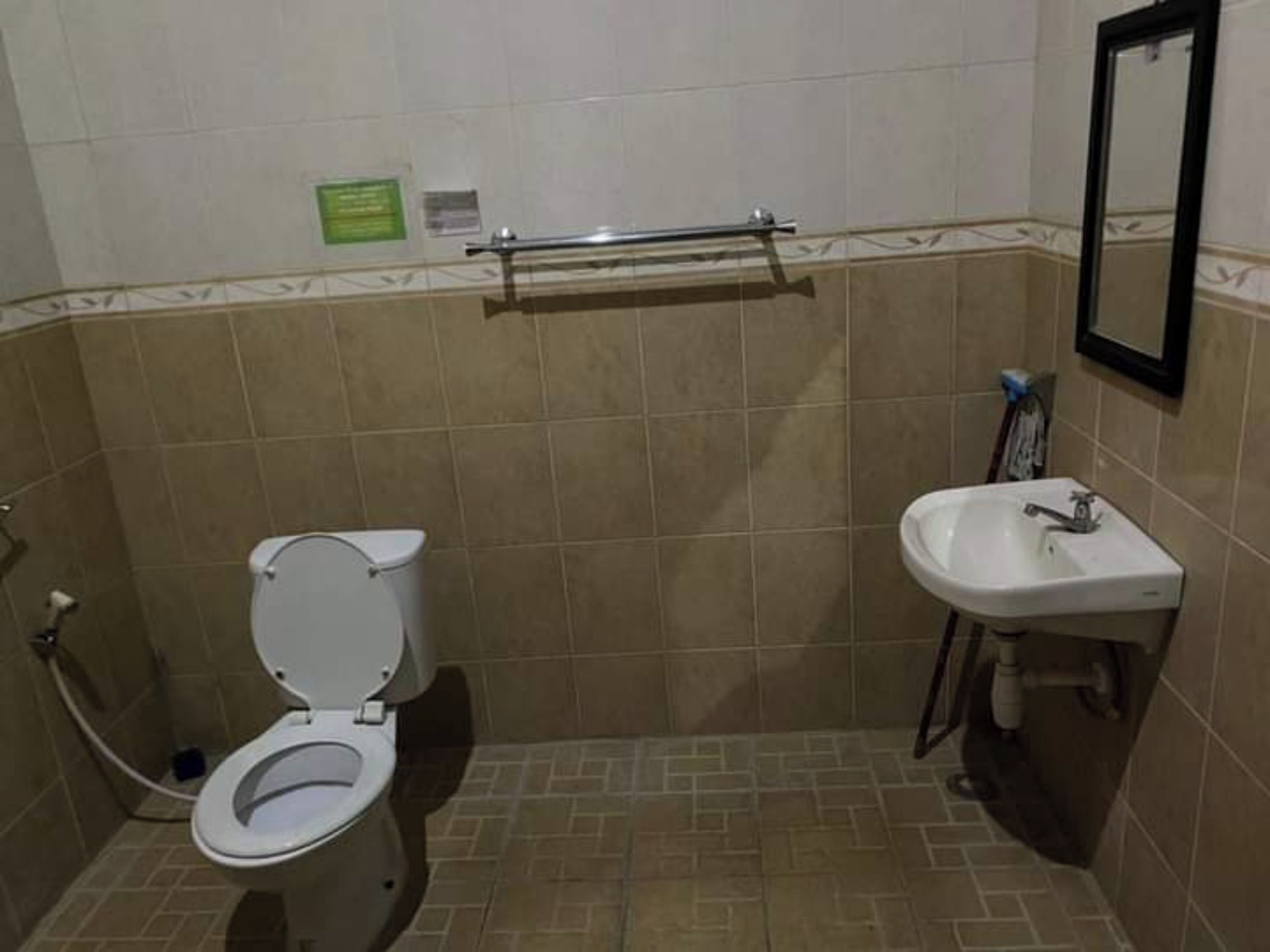 Un baño pequeño con inodoro, lavamanos y un perchero para toallas.