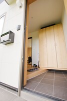 Un interior moderno con una puerta corredera de madera, un mueble de madera pequeño y un suelo de baldosas.
