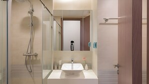 A modern bathroom with a glass shower enclosure, a white sink, and a mirror. - Vinhome Metropolis Service Apartment  (Hanoi)