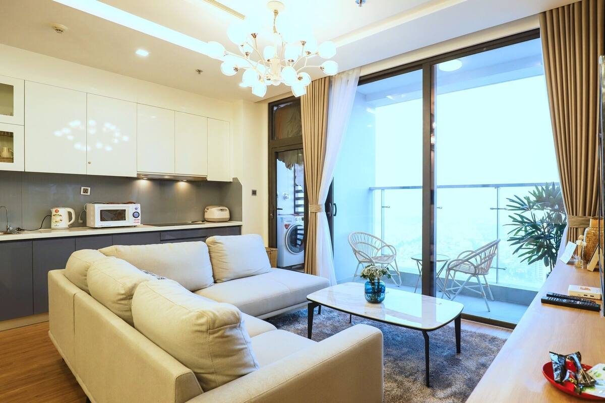 A modern living room with a sofa, a coffee table, and a view of the balcony.
