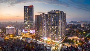 A high-rise building with multiple floors, a prominent sign at the top, and a well-lit facade. - Vinhome Metropolis Service Apartment  (Hanoi)