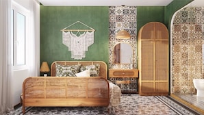Een kamer met een bed, een kaptafel, een spiegel en een behang met een patroon.
