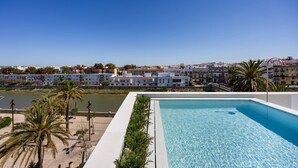 A clear blue pool with a view of a coastal town and a body of water. - Apartment 'Balcón Luxury 2' with Balcony, Wi-Fi and Air Conditioning (CHICLANA DE LA FRONTERA)