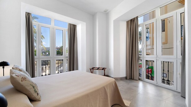 A bedroom with a bed, large windows, and a view of the outside. - Apartment 'Balcón Luxury 2' with Balcony, Wi-Fi and Air Conditioning (CHICLANA DE LA FRONTERA)