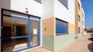 Un edificio con puerta de vidrio, marco de puerta azul y ventana con persiana azul.