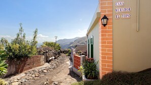Un estrecho sendero de piedra que lleva a un edificio con un letrero que dice 'CASA MIRADOR EL TOPO'.