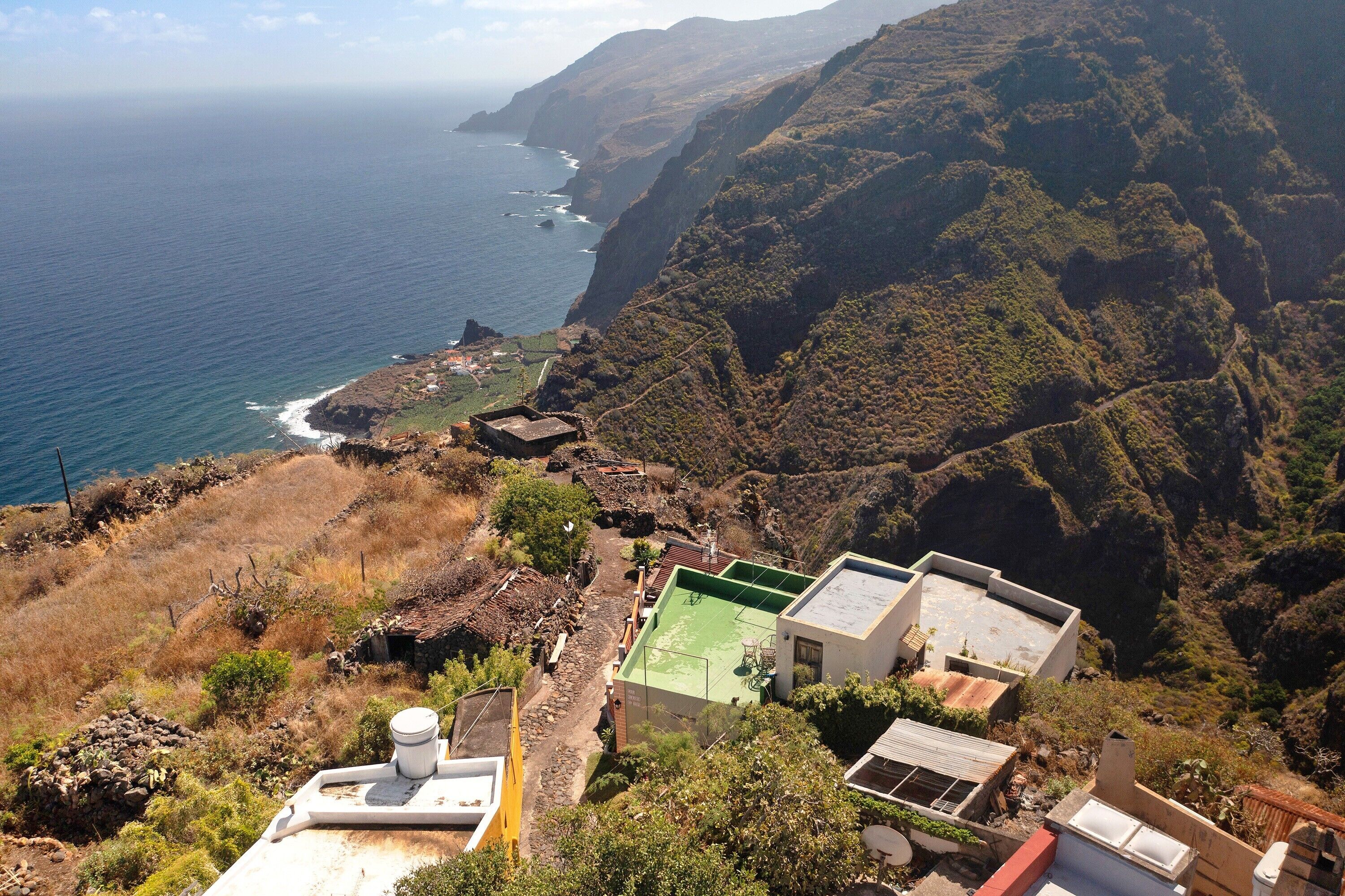 A coastal view with buildings on a hillside, overlooking the ocean.