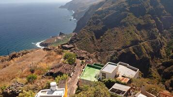 A coastal view with buildings on a hillside, overlooking the ocean.
