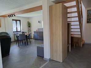 Un interior moderno con comedor, cocina y escalera.
