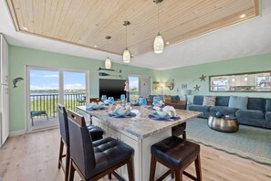A modern kitchen with a central island, bar stools, and pendant lighting.