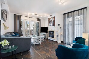 Un salon moderne comprenant un canapé, un téléviseur, une cheminée et un coin repas.
