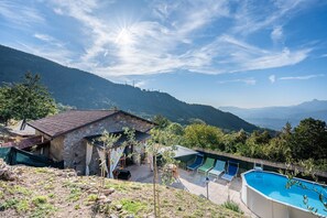 A stone building with a pool, outdoor seating, and a view of mountains. - Vacation Home "Agriturismo La Vecchia Scuola" with Private Mini Pool, Private Terraces & Wi-Fi (villa collemandina)