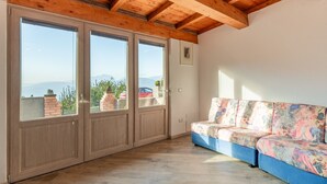 Una habitación con techo de madera, un sofá y vistas amplias a través de puertas de vidrio.
