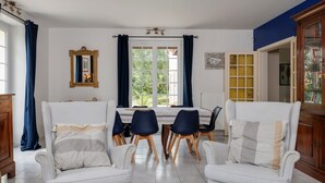 Un espace repas comprenant une table, des chaises et une vue par la fenêtre.