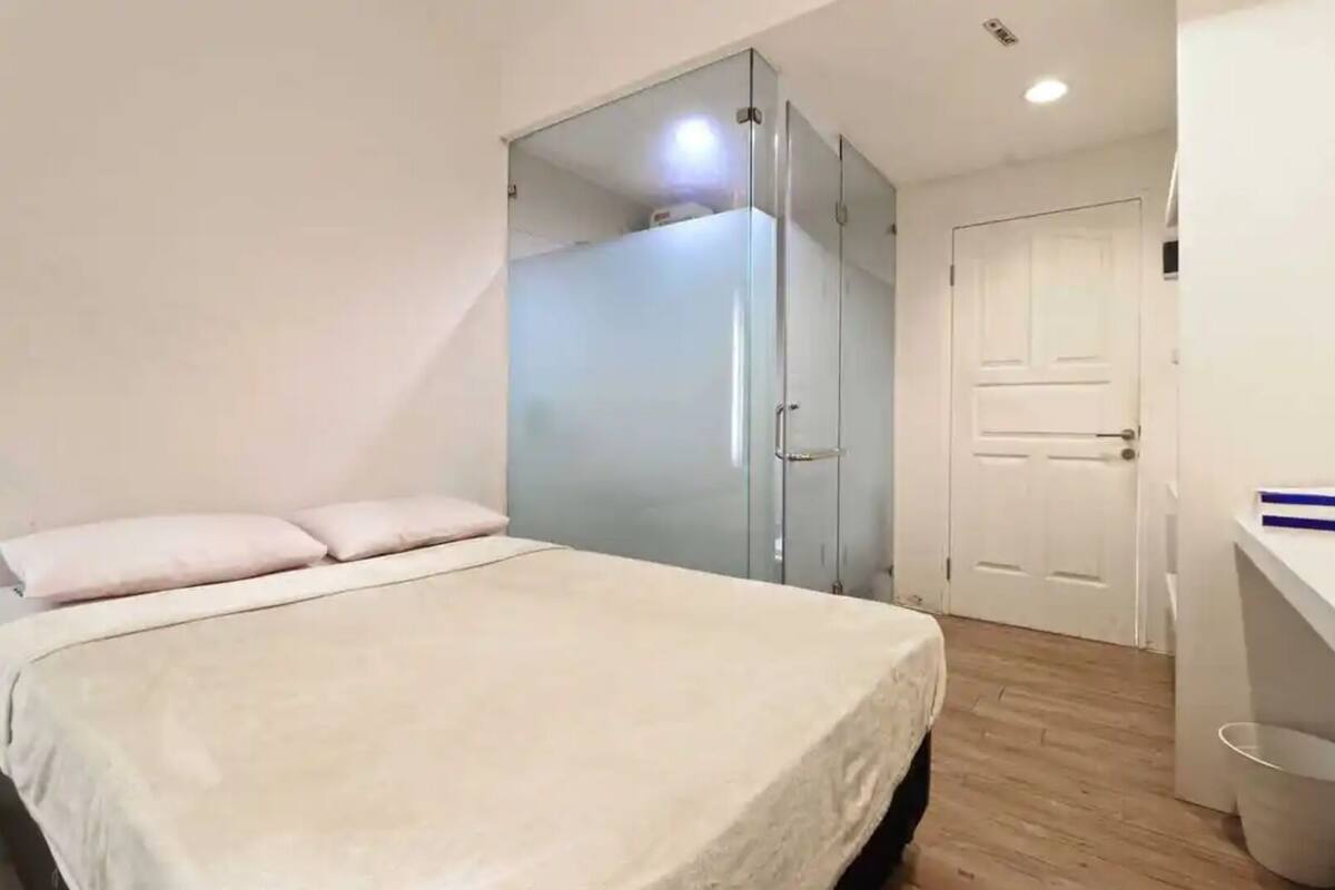 A bedroom with a bed, a wardrobe, and a door.