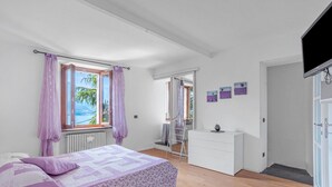 A bedroom with a bed, a dresser, and a TV. - Casa Valleggia (Moltrasio)