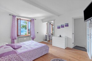 Un dormitorio con una cama, un aparador y un televisor.