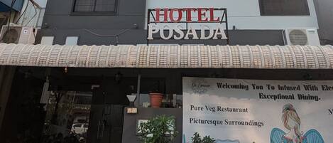 Hotel Posada, con un letrero que indica que es un restaurante vegetariano y ofrece un entorno pintoresco.