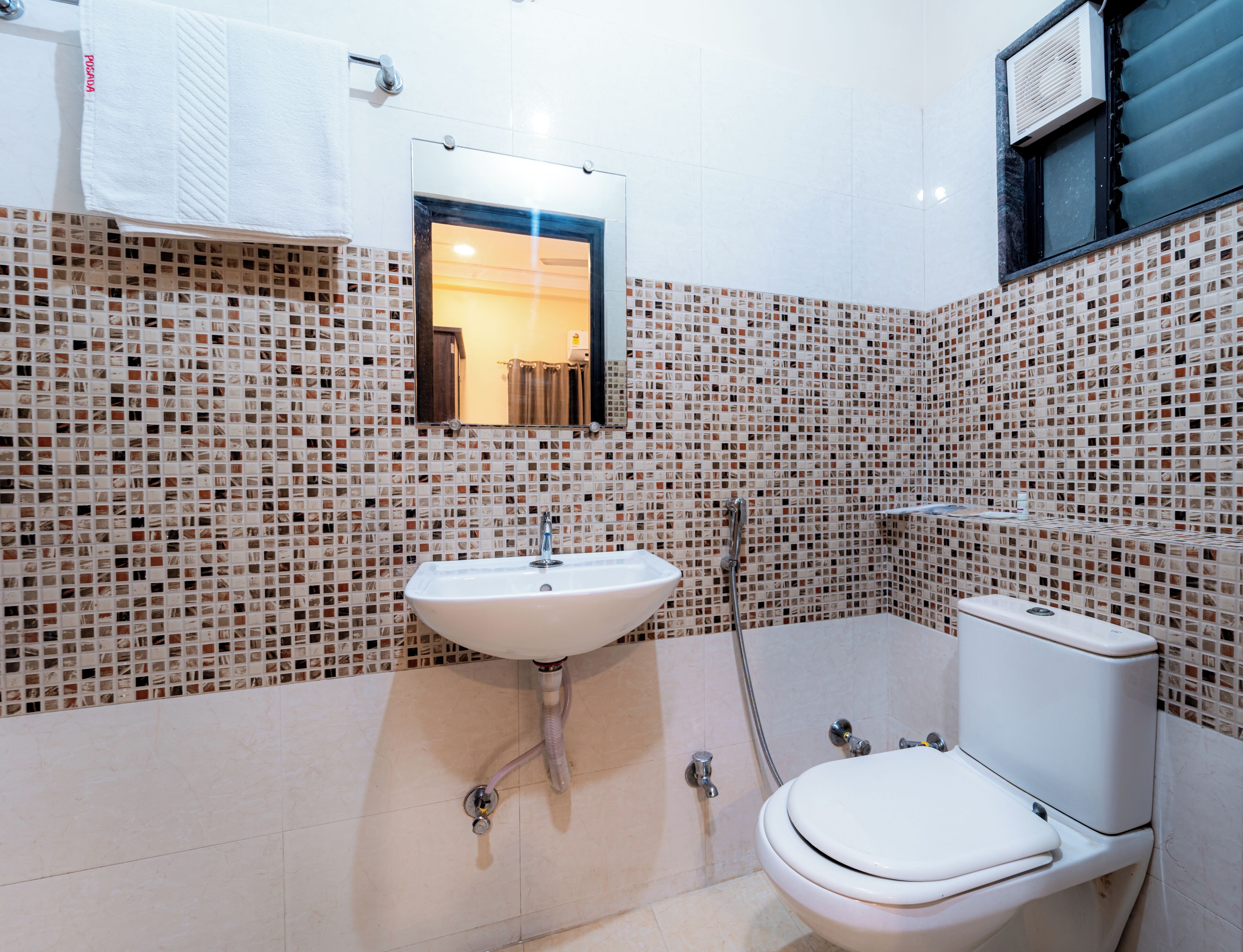Een badkamer met een witte wastafel, een toilet en een douche.