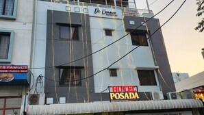 Un hôtel appelé « Hotel Posada », avec une enseigne, un restaurant nommé « De Limone Restaurant » situé juste au-dessus, et des plantes en pot devant l’entrée.