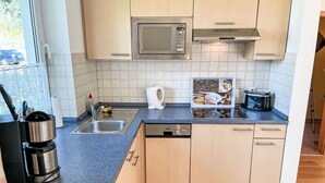 A compact kitchen with a microwave, toaster, and dishwasher. - Vacation home Maria by Interhome (Zinnowitz)