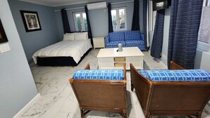 Un dormitorio con cama, sofá, mesa y dos sillas.