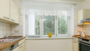 Eine Küche mit Fenster, einem gelben Spielzeug und einem Geschirrspüler.
